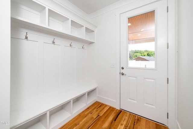 mudroom featuring light wood finished floors, crown molding, and baseboards