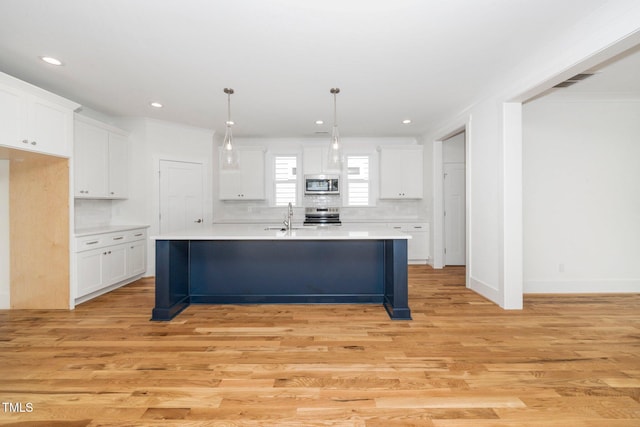 kitchen featuring appliances with stainless steel finishes, white cabinetry, light countertops, recessed lighting, and crown molding