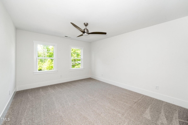 carpeted empty room featuring baseboards and ceiling fan