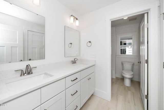 full bathroom with double vanity and toilet