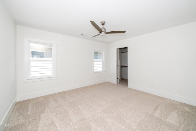 unfurnished bedroom with light carpet, baseboards, and a ceiling fan