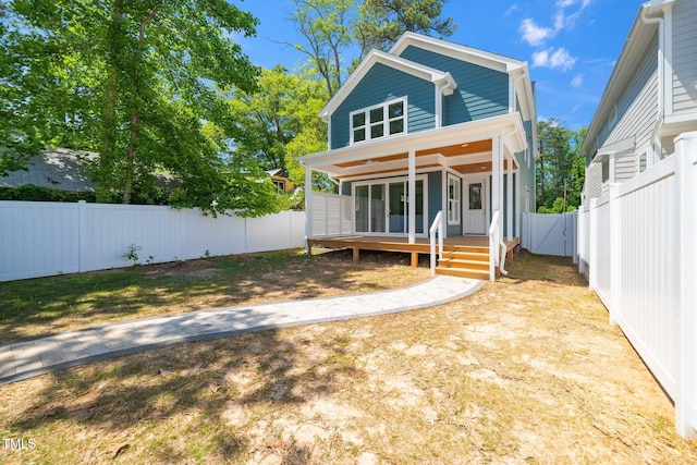 rear view of property featuring a fenced backyard