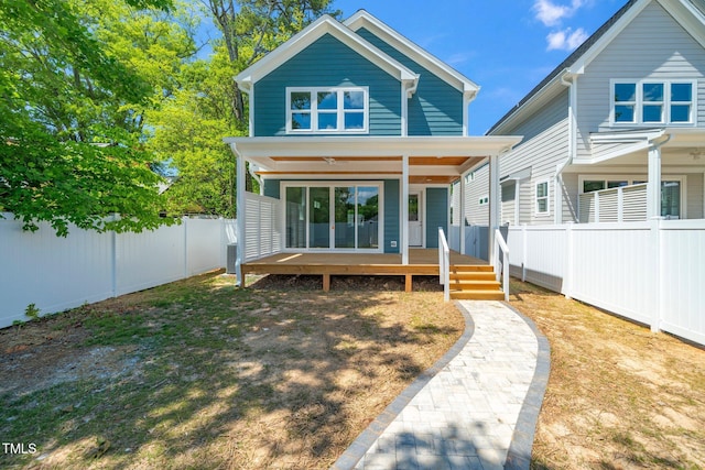 rear view of house featuring a fenced backyard