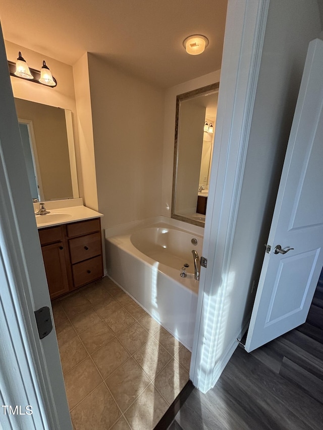 bathroom with a bath, vanity, and tile patterned floors