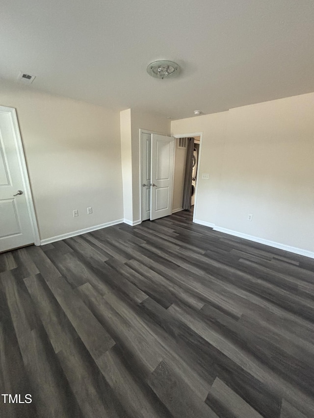 unfurnished bedroom with baseboards and dark wood-style floors