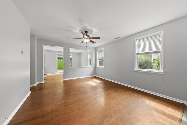 spare room featuring ceiling fan, baseboards, and wood finished floors