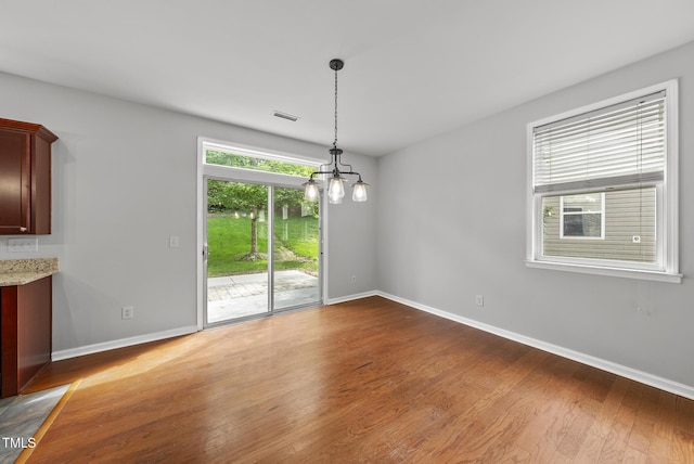 unfurnished dining area featuring wood finished floors and baseboards