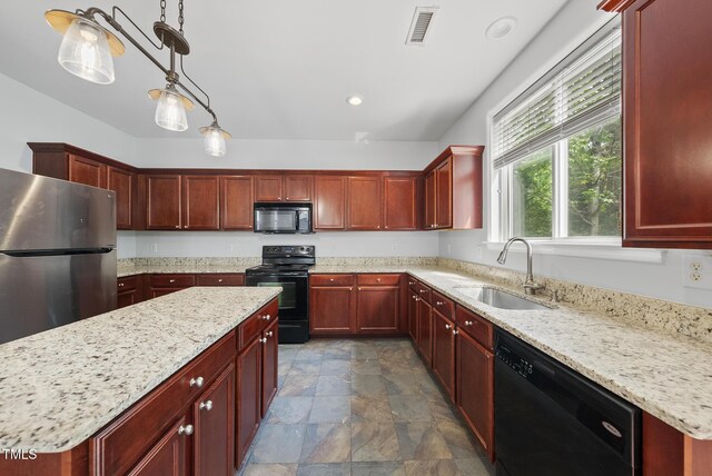 kitchen featuring black appliances, a sink, reddish brown cabinets, stone finish floors, and recessed lighting