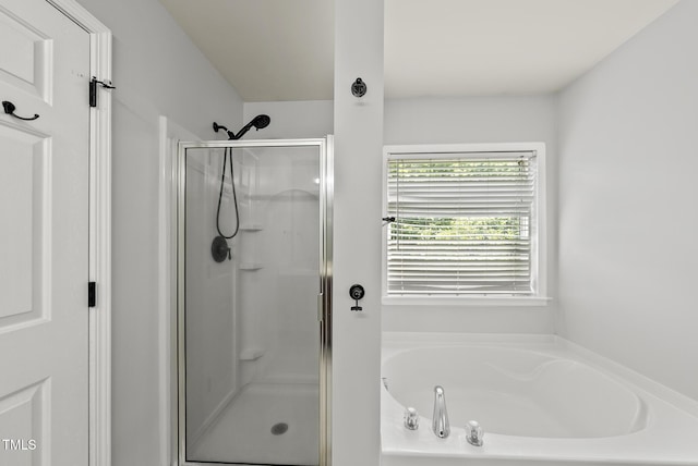 full bathroom with a shower stall and a bath