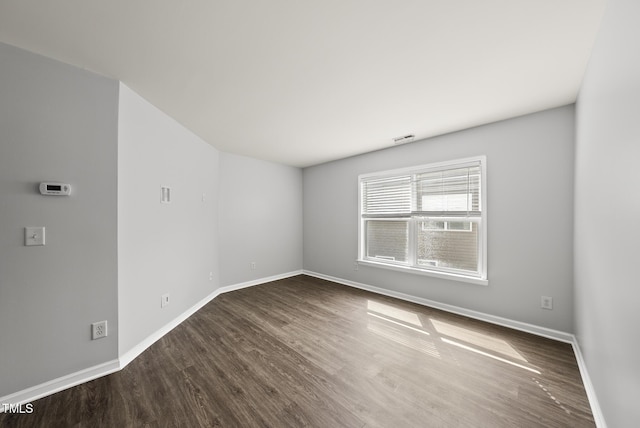 spare room with wood finished floors and baseboards