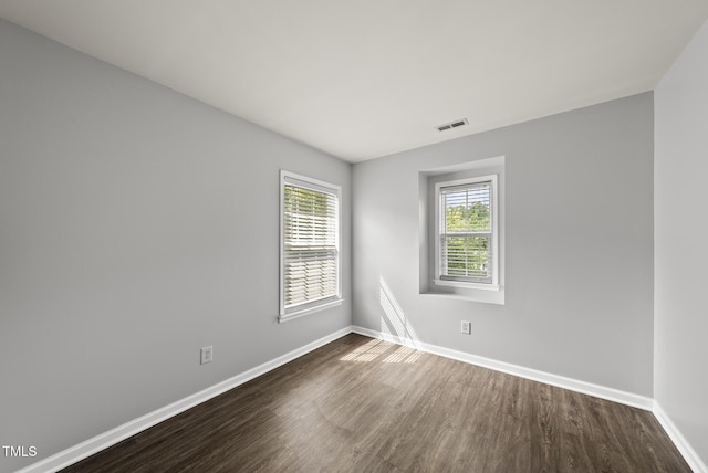 spare room with dark wood-style floors and baseboards