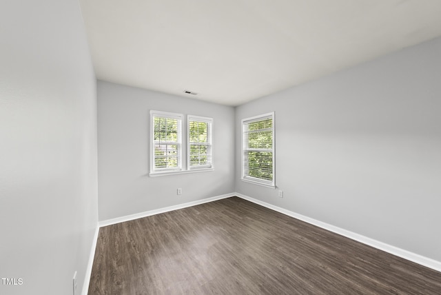 unfurnished room with dark wood-style flooring and baseboards