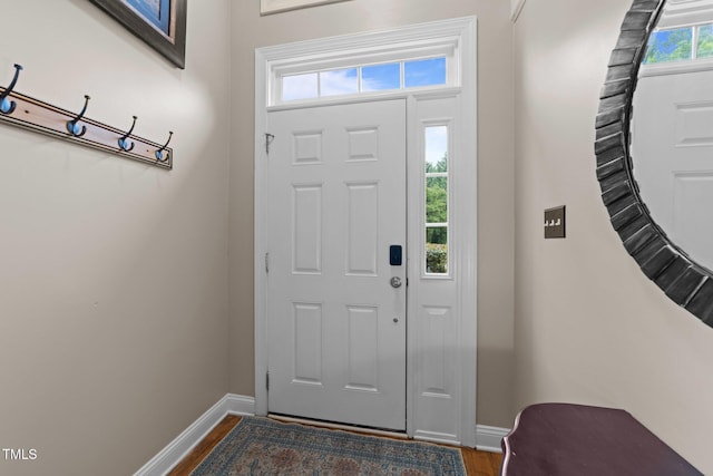 foyer featuring baseboards and dark wood-type flooring