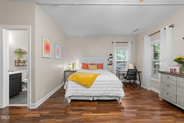 bedroom with wood finished floors, baseboards, and connected bathroom