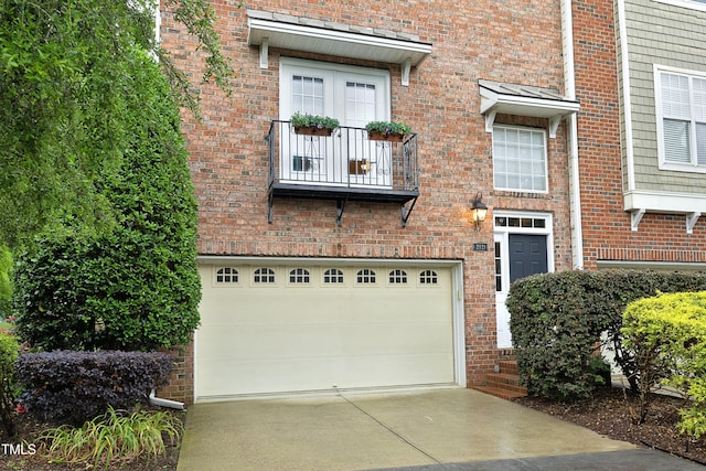 view of front of house featuring driveway, an attached garage, and brick siding