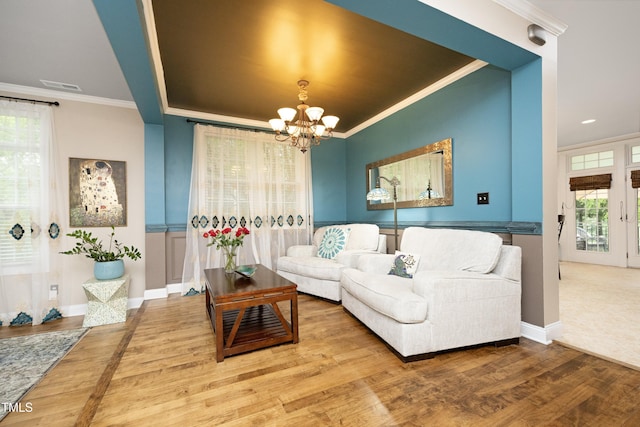 living room featuring ornamental molding, a chandelier, wood finished floors, and baseboards