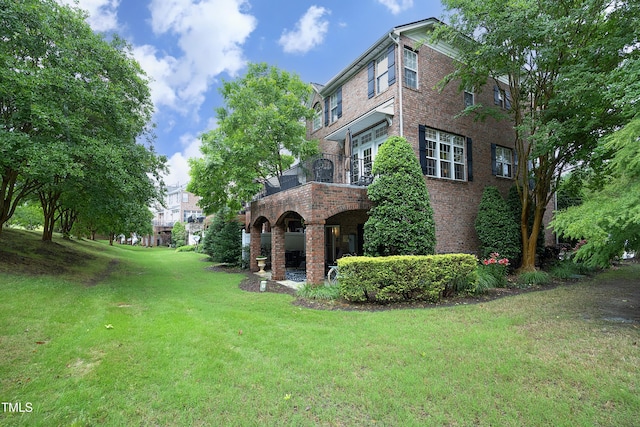 view of green lawn with a balcony