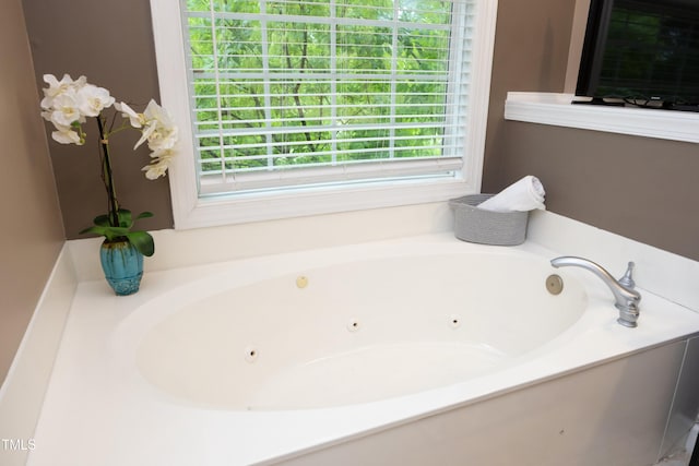 bathroom with a tub with jets