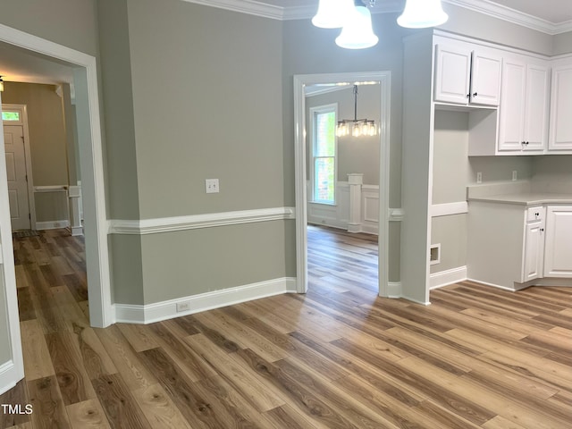 8100 Laurel Mountain Rd, Raleigh, NC 27613 - kitchen featuring a chandelier, white cabinetry, light wood-style flooring, ornamental molding, and light countertops
