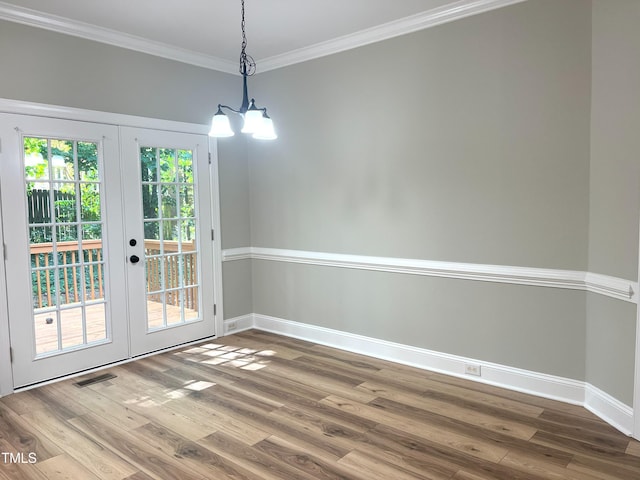 8100 Laurel Mountain Rd, Raleigh, NC 27613 - unfurnished dining area featuring wood finished floors, french doors, ornamental molding, and a chandelier