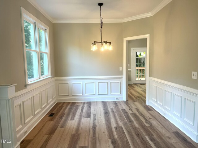 8100 Laurel Mountain Rd, Raleigh, NC 27613 - unfurnished dining area featuring a chandelier, dark wood-style floors, ornamental molding, wainscoting, and a decorative wall