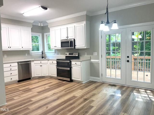 8100 Laurel Mountain Rd, Raleigh, NC 27613 - kitchen with appliances with stainless steel finishes, light wood-style floors, light countertops, white cabinetry, and crown molding