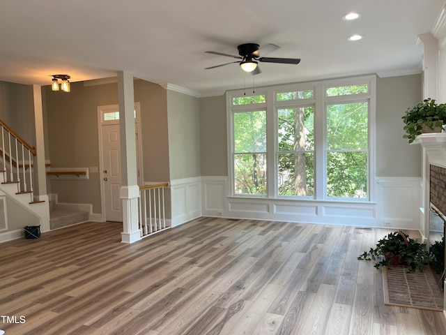 8100 Laurel Mountain Rd, Raleigh, NC 27613 - unfurnished living room with a ceiling fan, wood finished floors, crown molding, wainscoting, and stairway