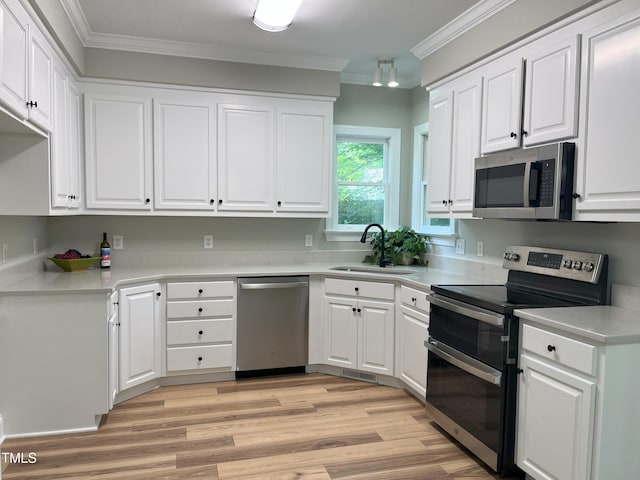 8100 Laurel Mountain Rd, Raleigh, NC 27613 - kitchen with stainless steel appliances, ornamental molding, white cabinetry, light wood-style floors, and light countertops