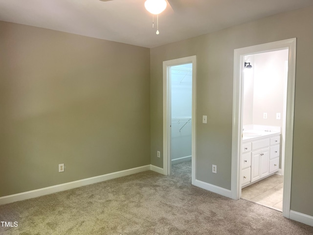 8100 Laurel Mountain Rd, Raleigh, NC 27613 - unfurnished bedroom featuring light carpet, a spacious closet, connected bathroom, a closet, and ceiling fan