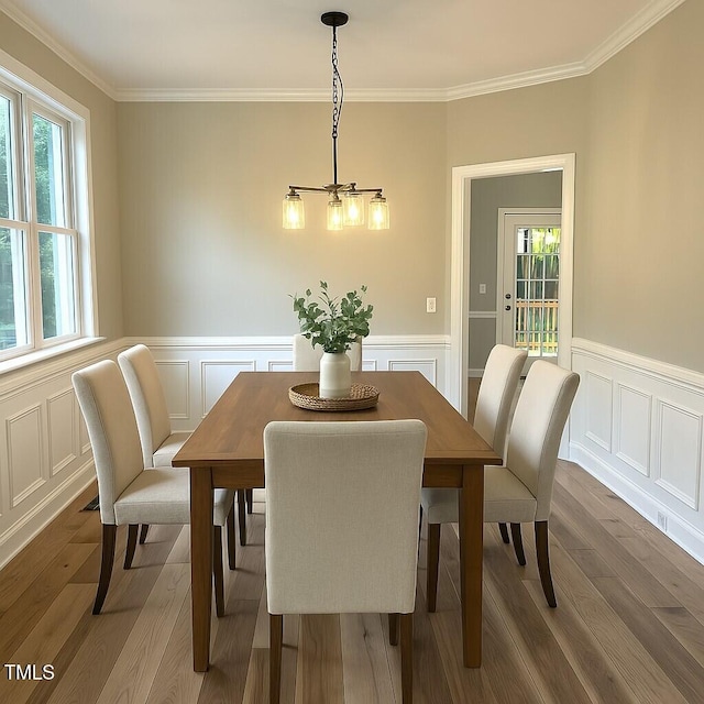8100 Laurel Mountain Rd, Raleigh, NC 27613 - dining area featuring healthy amount of natural light, crown molding, wainscoting, a decorative wall, and wood finished floors