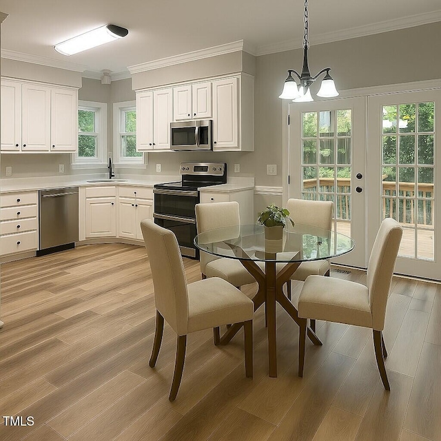 8100 Laurel Mountain Rd, Raleigh, NC 27613 - dining space featuring light wood-style floors, ornamental molding, and a chandelier