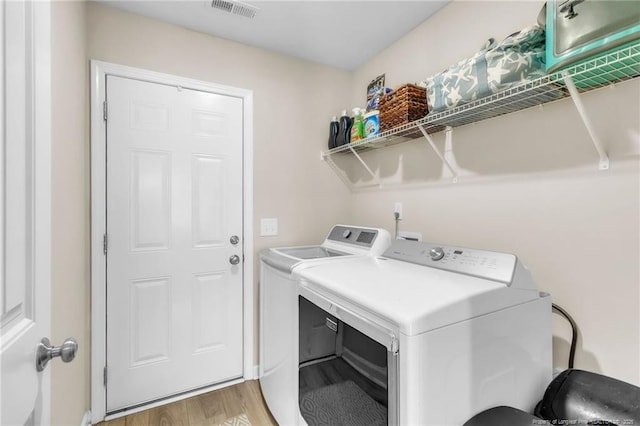 6955 S W St, Godwin, NC 28344 - clothes washing area with washing machine and clothes dryer and light wood-style floors