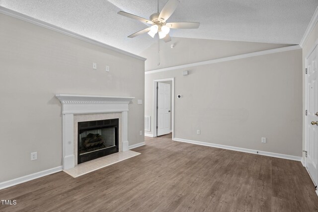 765 S Hollybrook Rd, Wendell, NC 27591 - unfurnished living room with a ceiling fan, vaulted ceiling, a tile fireplace, a textured ceiling, and wood finished floors