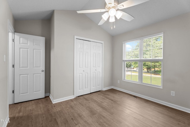 765 S Hollybrook Rd, Wendell, NC 27591 - unfurnished bedroom with wood finished floors, baseboards, a closet, and vaulted ceiling