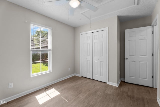 765 S Hollybrook Rd, Wendell, NC 27591 - unfurnished bedroom with attic access, multiple windows, wood finished floors, a closet, and a textured ceiling