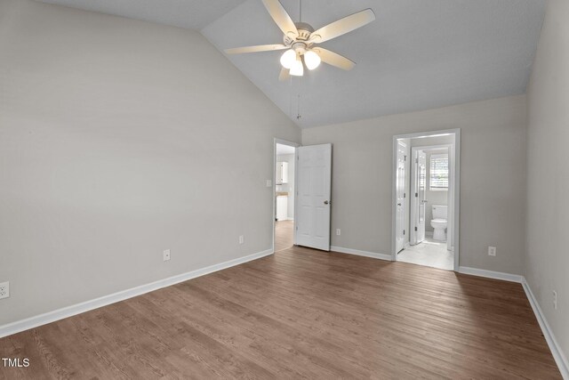 765 S Hollybrook Rd, Wendell, NC 27591 - unfurnished bedroom with wood finished floors, baseboards, ensuite bathroom, and high vaulted ceiling