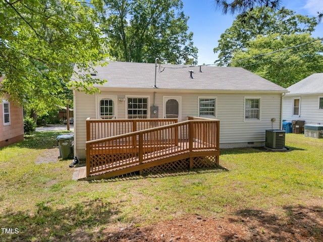 rear view of property featuring crawl space, cooling unit, a deck, and a lawn