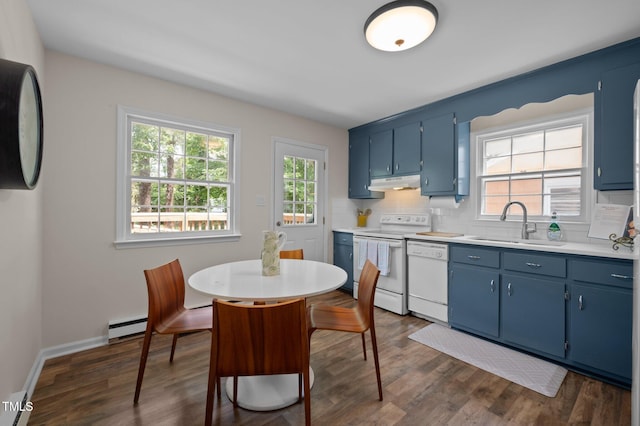 kitchen with white appliances, blue cabinets, under cabinet range hood, a sink, and a baseboard radiator