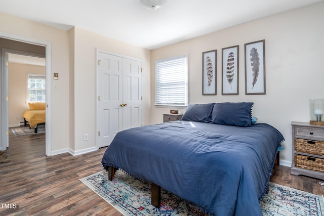 bedroom featuring dark wood finished floors, baseboards, and a closet
