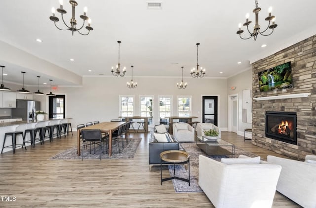 212 Sea Trail St, Hillsborough, NC 27278 - living room with a chandelier, light wood-style flooring, a fireplace, recessed lighting, and crown molding