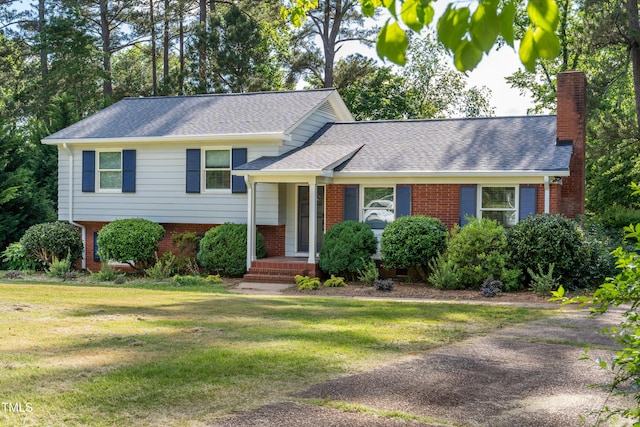 4813 Glen Forest Dr, Raleigh, NC 27612 - split level home featuring brick siding, a front lawn, a chimney, and a shingled roof