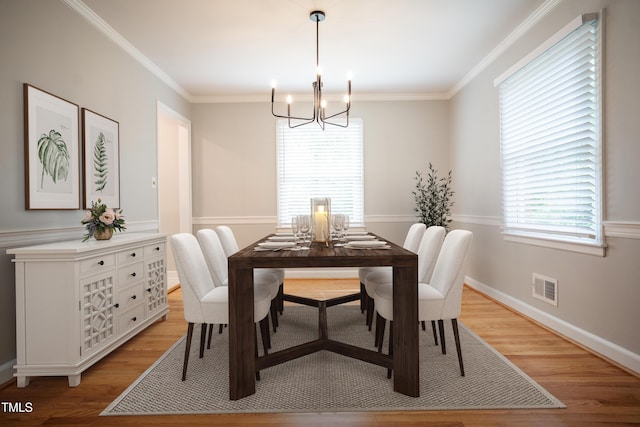 4813 Glen Forest Dr, Raleigh, NC 27612 - dining room with a chandelier, light wood-type flooring, crown molding, and baseboards