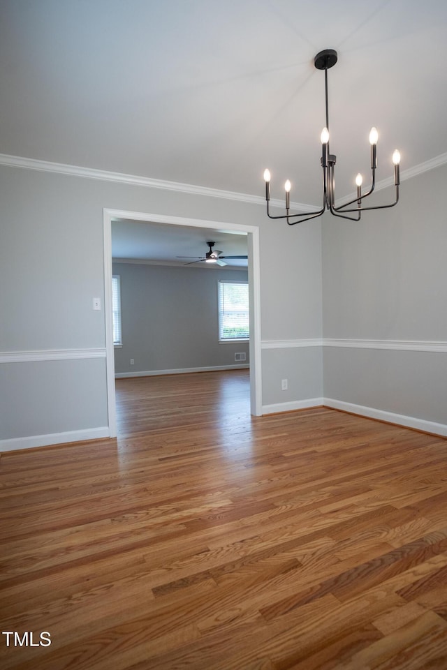 4813 Glen Forest Dr, Raleigh, NC 27612 - empty room featuring a chandelier, crown molding, wood finished floors, baseboards, and ceiling fan