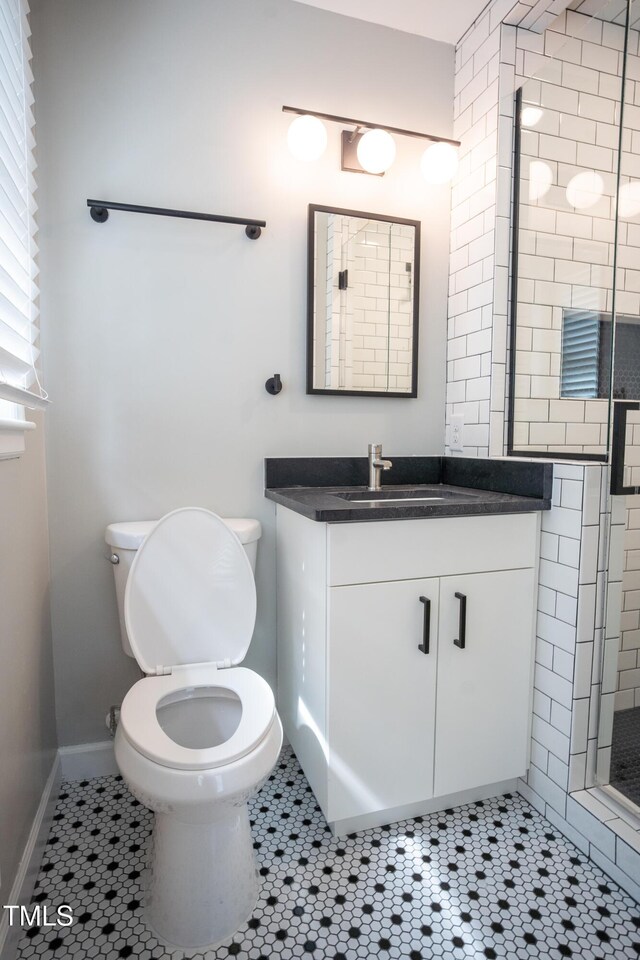 4813 Glen Forest Dr, Raleigh, NC 27612 - bathroom featuring toilet, vanity, a shower stall, tile patterned flooring, and baseboards