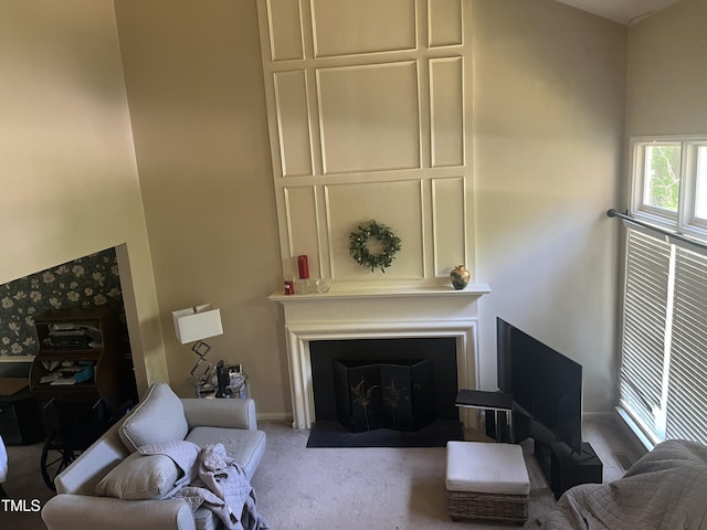 living area featuring carpet floors, baseboards, and a fireplace with flush hearth
