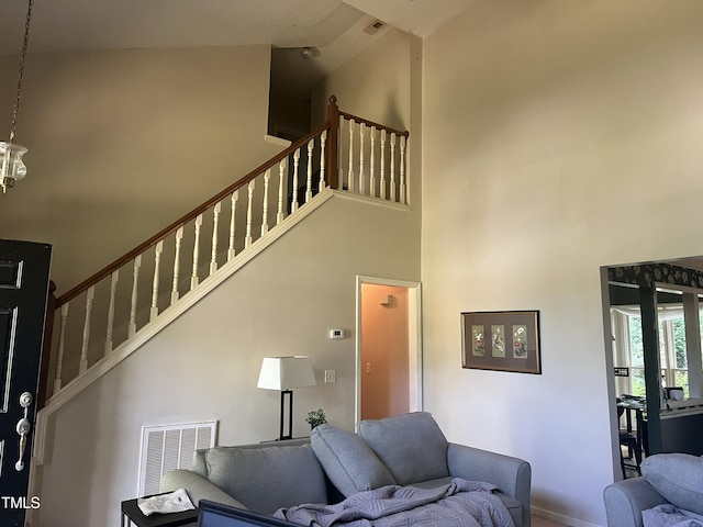 living room featuring high vaulted ceiling, stairs, and baseboards