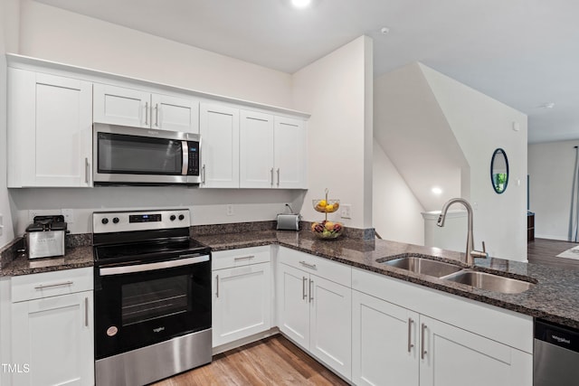 4157 Trevino Dr, Durham, NC 27704 - kitchen with appliances with stainless steel finishes, a sink, dark stone counters, and white cabinetry