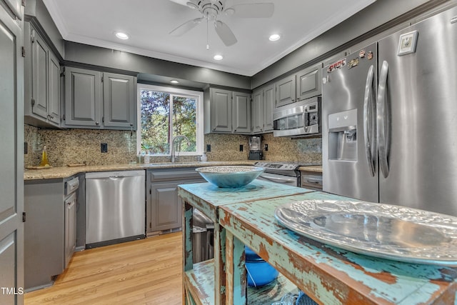 10909 Raven Rock Dr, Raleigh, NC 27614 - kitchen featuring appliances with stainless steel finishes, gray cabinets, a sink, ornamental molding, and light wood-type flooring