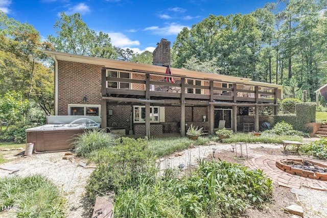10909 Raven Rock Dr, Raleigh, NC 27614 - rear view of house featuring a hot tub, a fire pit, brick siding, a wooden deck, and a chimney