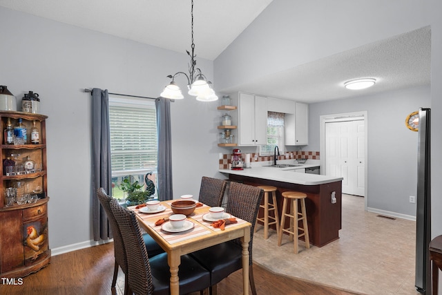 687 W Watson Rd, Benson, NC 27504 - dining space featuring a chandelier, vaulted ceiling, and baseboards
